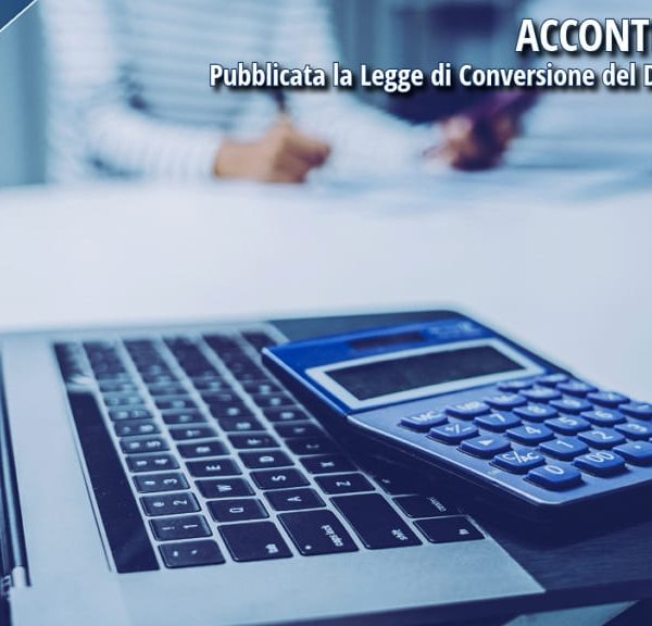 Calcolatrice e laptop su una scrivania durante una consulenza fiscale, con testo informativo sugli acconti IRPEF 2025.