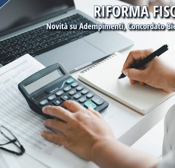 Persona al lavoro su documenti fiscali con calcolatrice e laptop, simbolo della riforma fiscale 2025