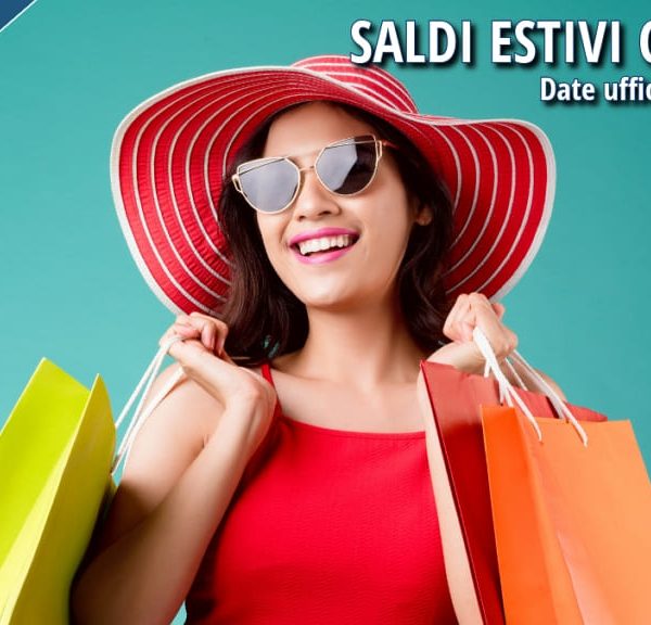 Ragazza vestita in abiti estivi, tiene in mano diverse buste di shopping colorate, approfittando dell’inizio della stagione estiva dei saldi.