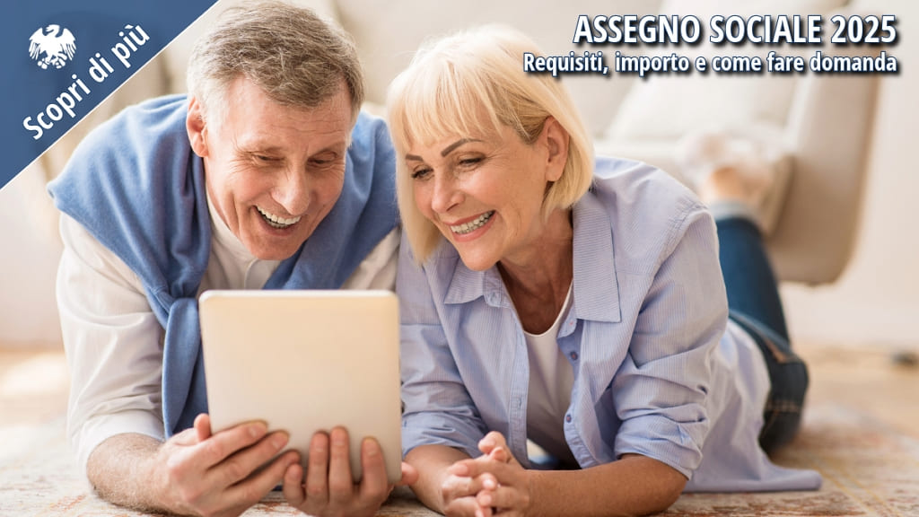 Coppia di anziani sorridenti che consulta un tablet per informarsi sull’assegno sociale 2025.