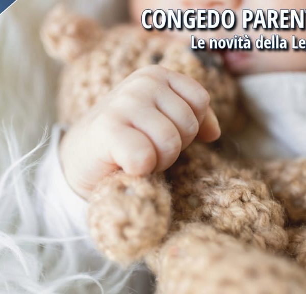 Mano di un neonato che stringe un orsacchiotto di lana, simbolo del congedo parentale 2025 e delle nuove misure a sostegno dei genitori.
