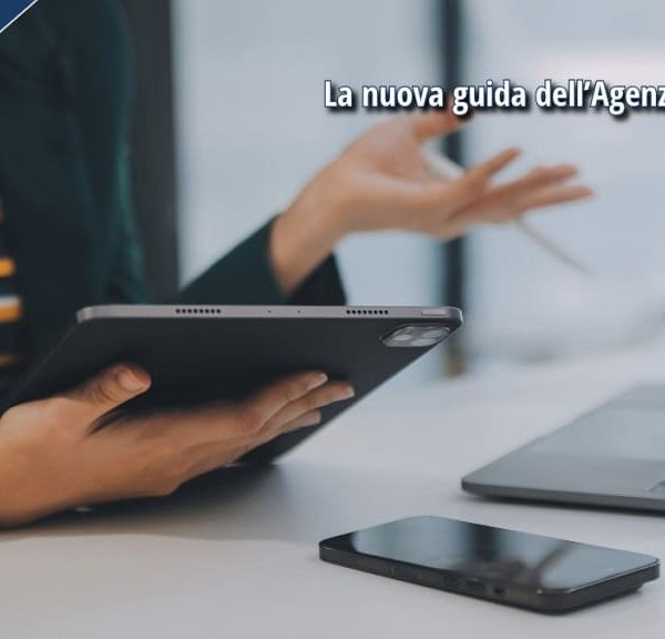 Persona al lavoro su tablet e laptop con didascalia, mentre fornisce una consulenza fiscale.