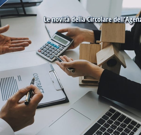 Due professionisti al lavoro con calcolatrice, modelli di casa e documenti contrattuali su un tavolo, simbolo delle novità fiscali ISA 2024.