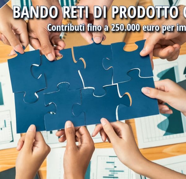 Degli imprenditori che compongono insieme un puzzle blu, simbolo di cooperazione.