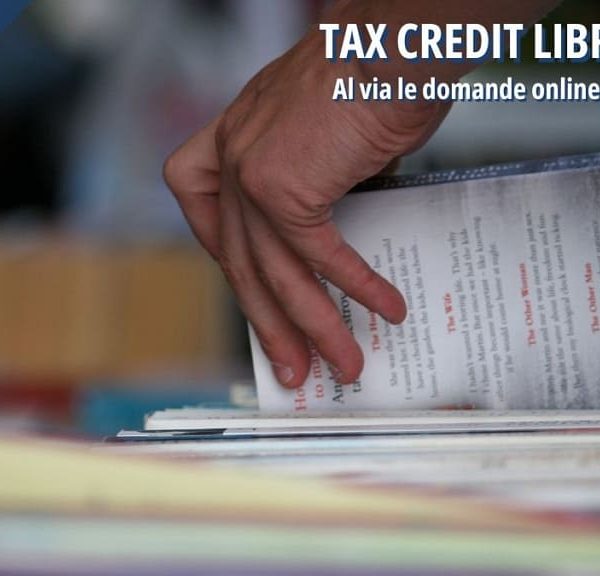 Una mano che sfoglia dei libri in una libreria, a simboleggiare la "Tax Credit Librerie 2025" e la possibilità di presentare le domande online dal 15 settembre.