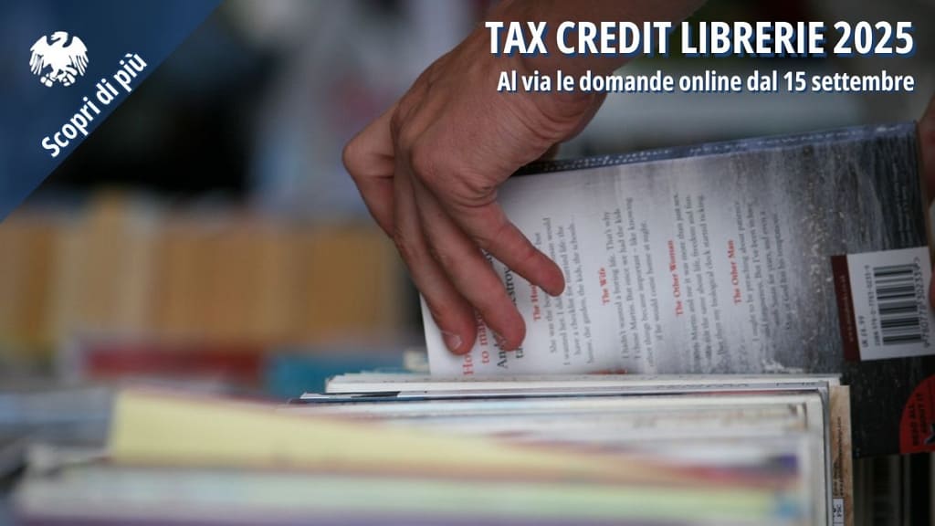 Una mano che sfoglia dei libri in una libreria, a simboleggiare la "Tax Credit Librerie 2025" e la possibilità di presentare le domande online dal 15 settembre.