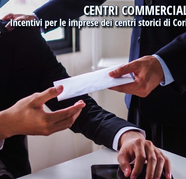 Due uomini d’affari si scambiano una busta, simbolo di incentivi e sostegno economico alle imprese dei centri storici di Corigliano-Rossano.