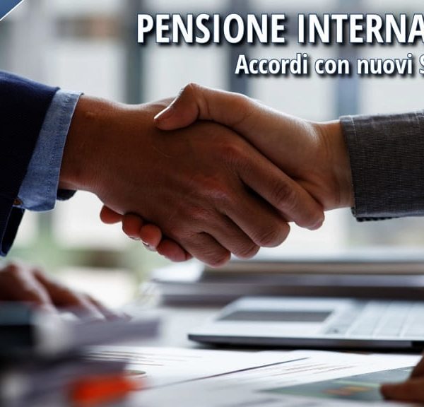 Due persone si stringono la mano sedute a una scrivania, a simboleggiare l'accordo internazionale sulla pensione.