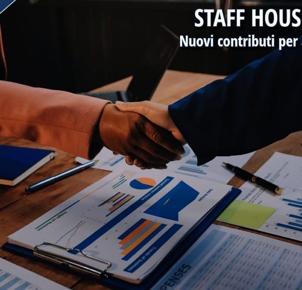 Stretta di mano tra professionisti su documenti aziendali, simbolo di accordo per investimenti in alloggi per lavoratori del turismo (Staff House).