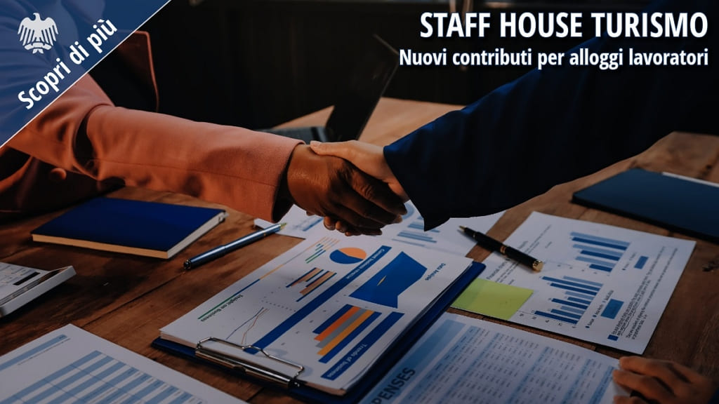 Stretta di mano tra professionisti su documenti aziendali, simbolo di accordo per investimenti in alloggi per lavoratori del turismo (Staff House).