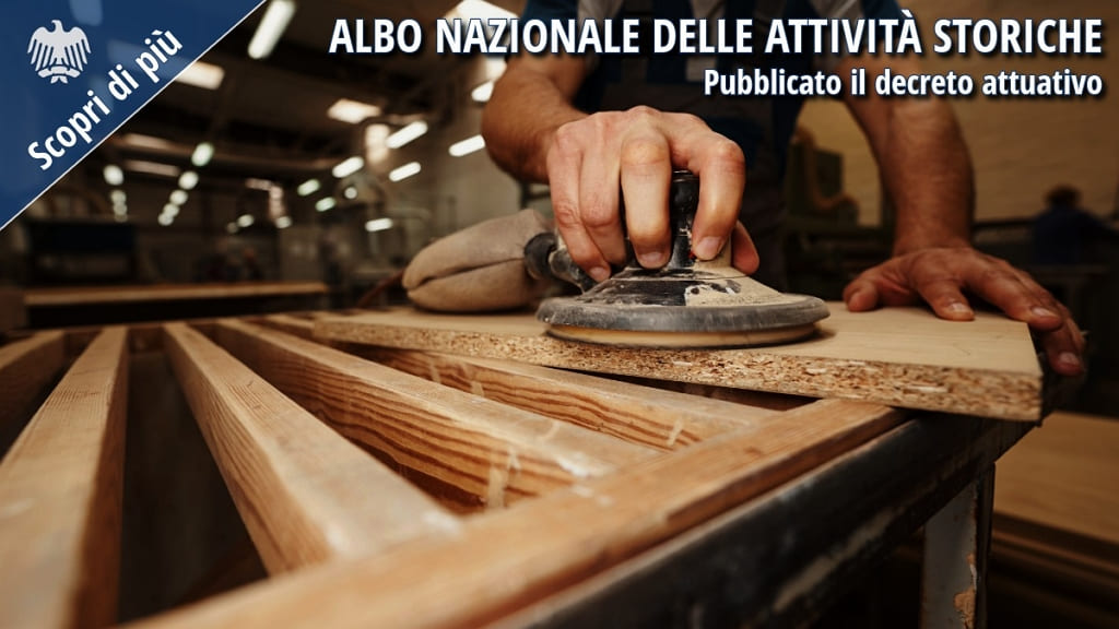 Artigiano al lavoro in una falegnameria mentre leviga un pannello in legno. L’immagine richiama il valore delle botteghe artigiane e delle attività storiche tutelate dal nuovo Albo nazionale.