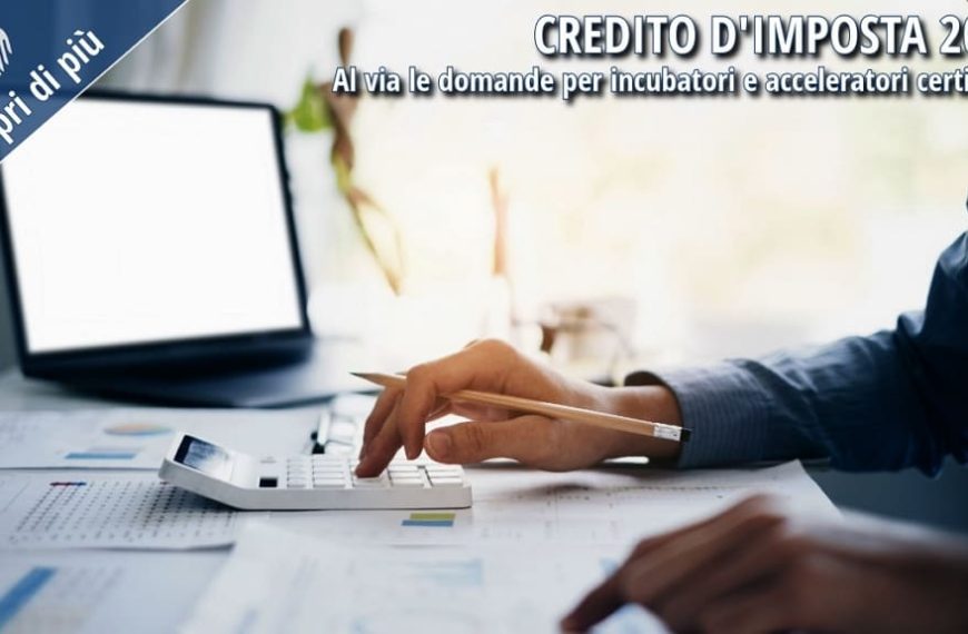 Persona impegnata nell'analisi di documenti finanziari e nell'utilizzo di una calcolatrice su una scrivania d'ufficio, immagine rappresentativa del credito d'imposta destinato a incubatori e acceleratori certificati.