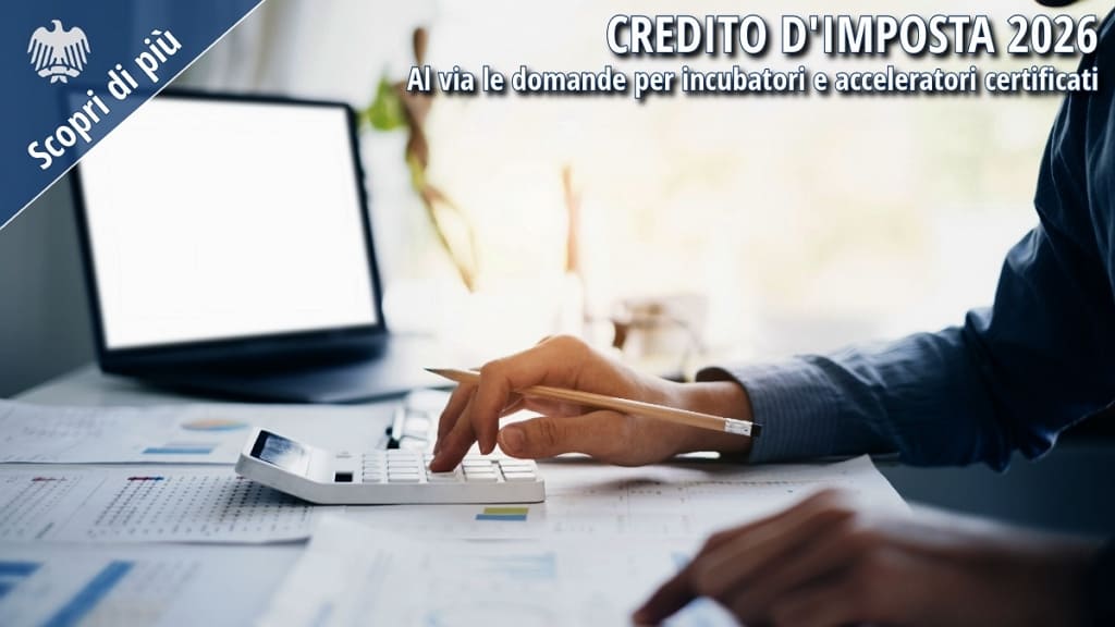 Persona impegnata nell'analisi di documenti finanziari e nell'utilizzo di una calcolatrice su una scrivania d'ufficio, immagine rappresentativa del credito d'imposta destinato a incubatori e acceleratori certificati.